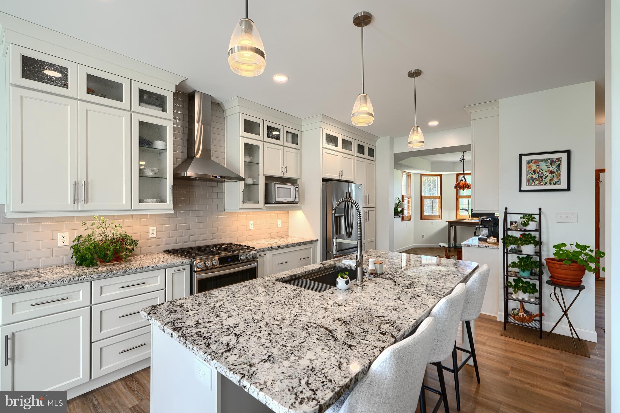 522 Little New York Road Rising Sun, MD 21911 - Photo 16 of 72 a kitchen with stainless steel appliances granite countertop a stove top oven a sink a dining table and chairs with wooden floor