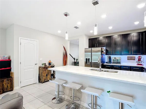 a kitchen with stainless steel appliances kitchen island granite countertop a sink and a refrigerator