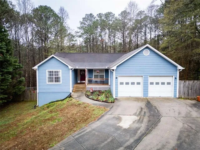 a front view of house with yard and trees in the background