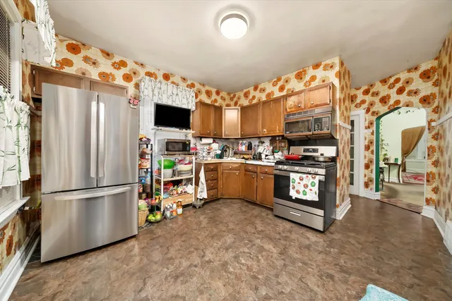 a kitchen with stainless steel appliances a stove a chimney and a refrigerator