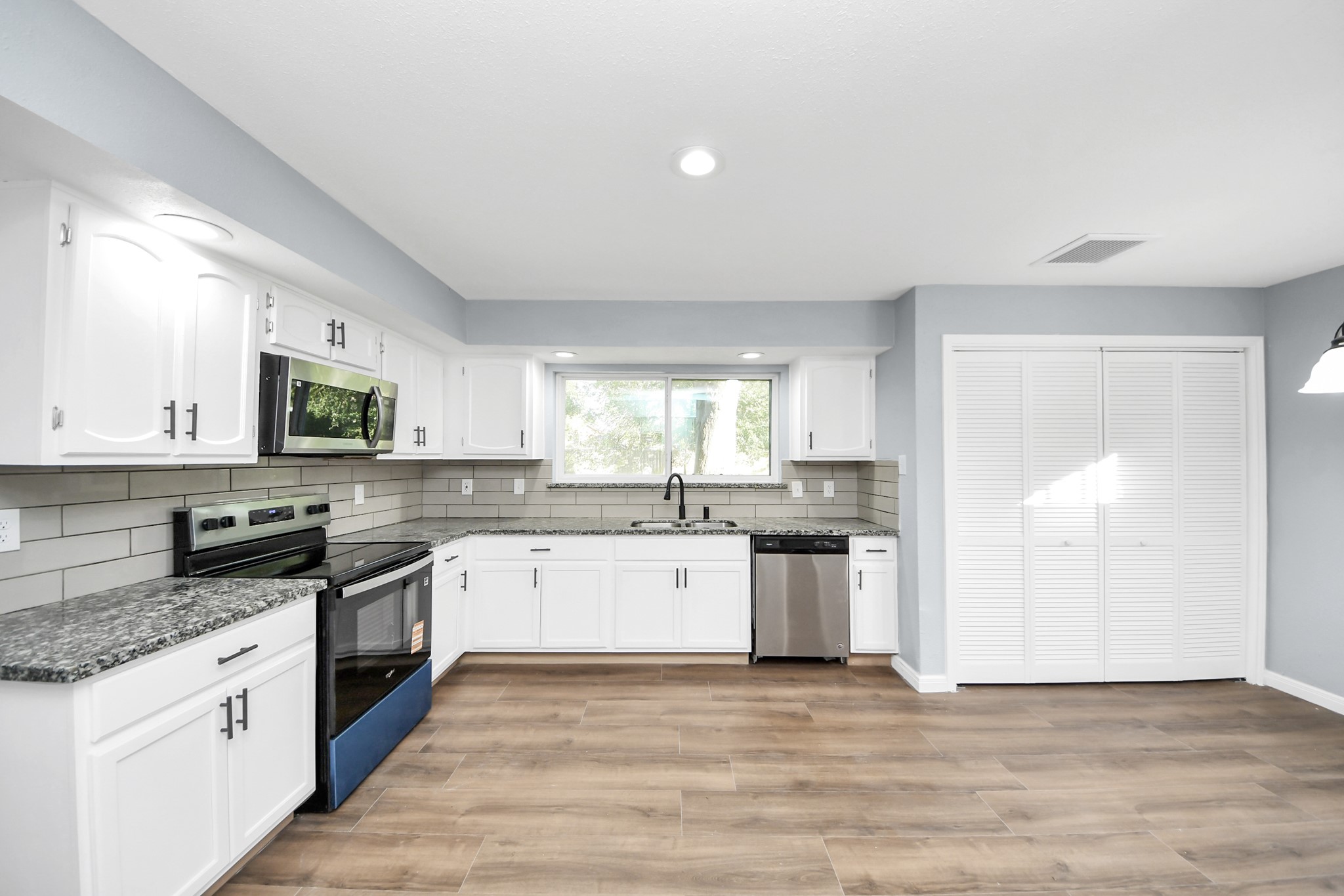 1806 Lacewing Lane Houston, TX 77067 - Photo 2 of 49 a large kitchen with a stove top oven a sink a dishwasher with wooden floor and cabinets