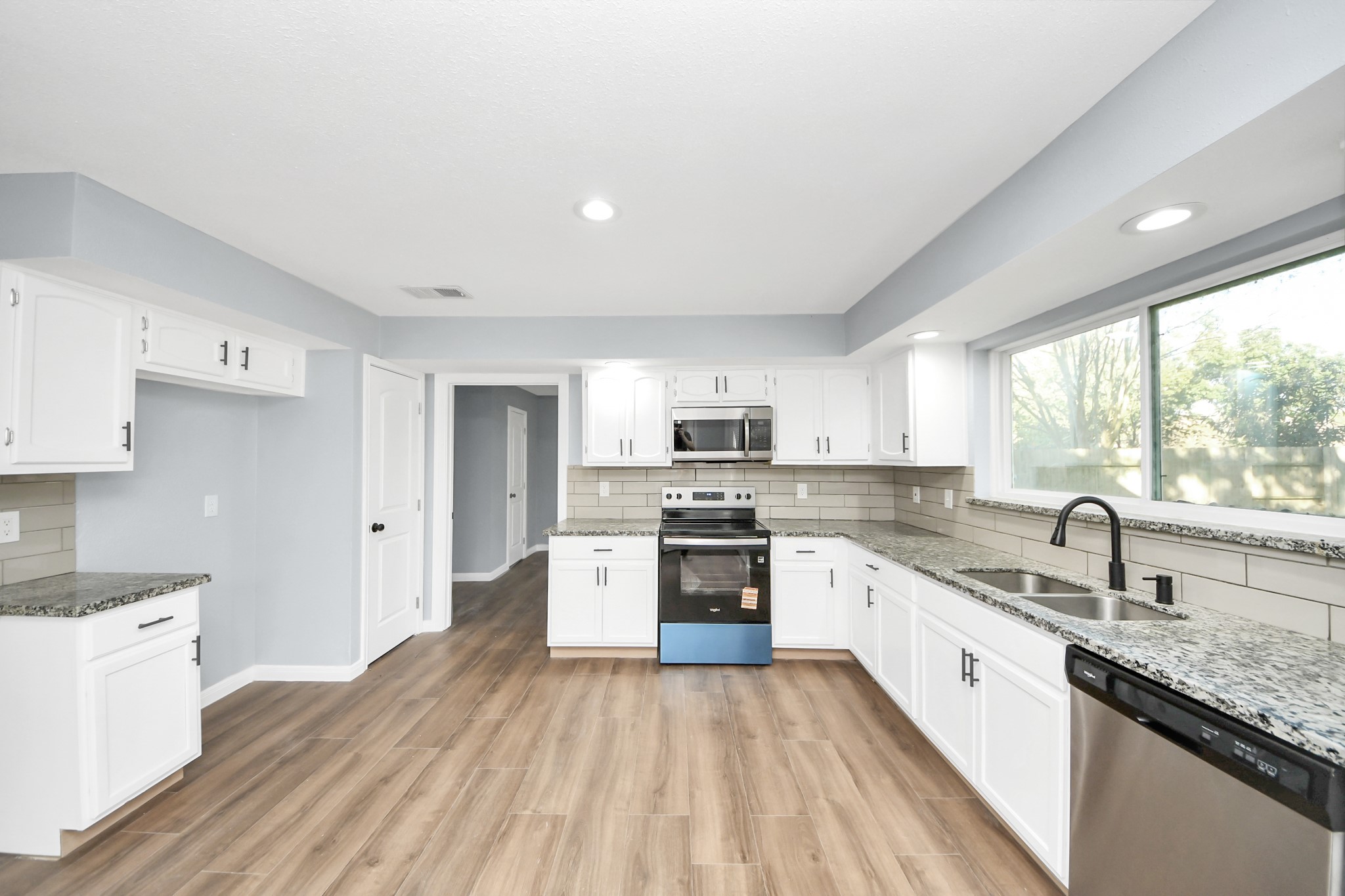 1806 Lacewing Lane Houston, TX 77067 - Photo 6 of 49 a large kitchen with stainless steel appliances granite countertop a lot of counter space and wooden floors