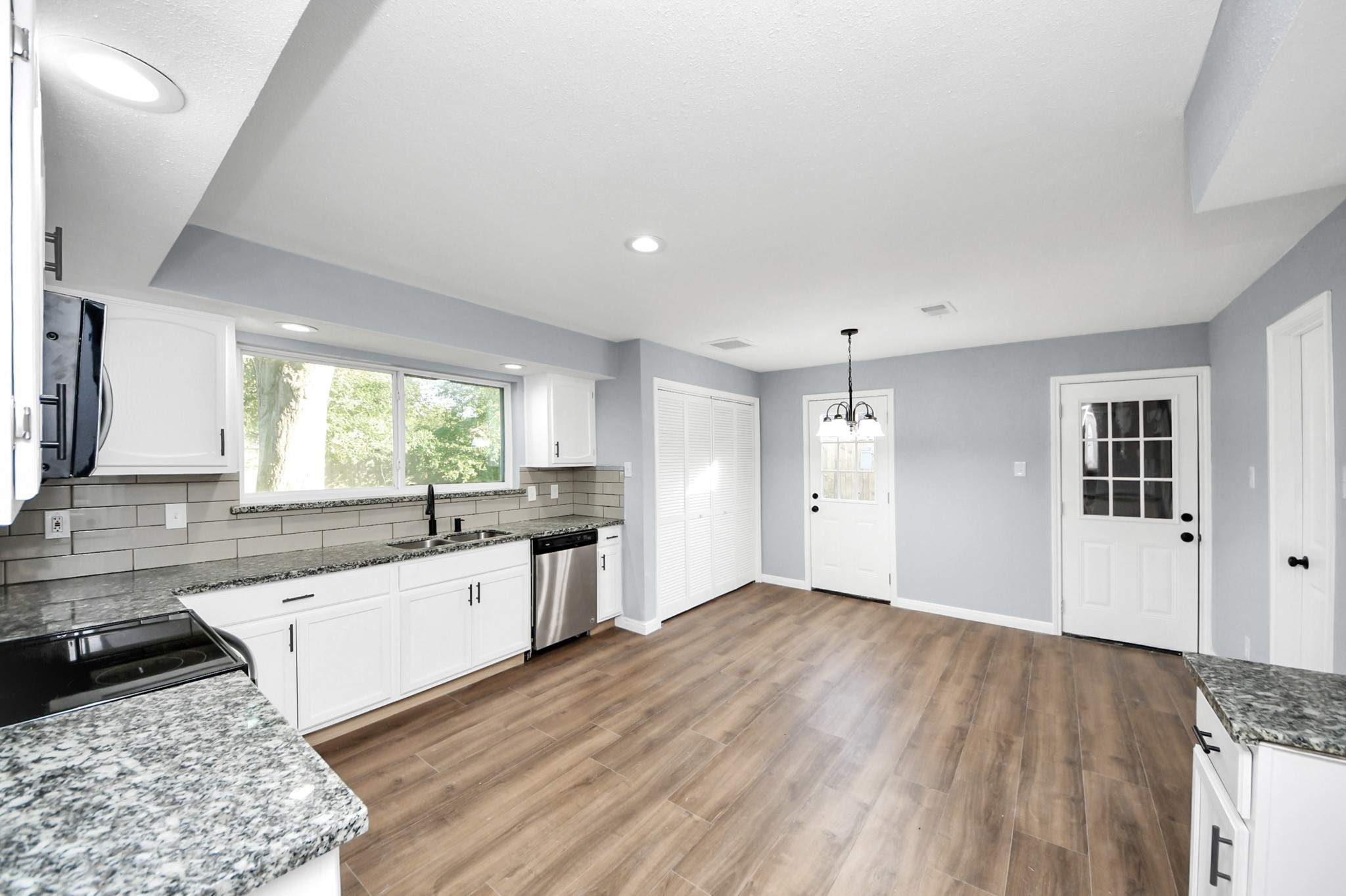 1806 Lacewing Lane Houston, TX 77067 - Photo 8 of 49 a large kitchen with granite countertop a large window a sink and stainless steel appliances