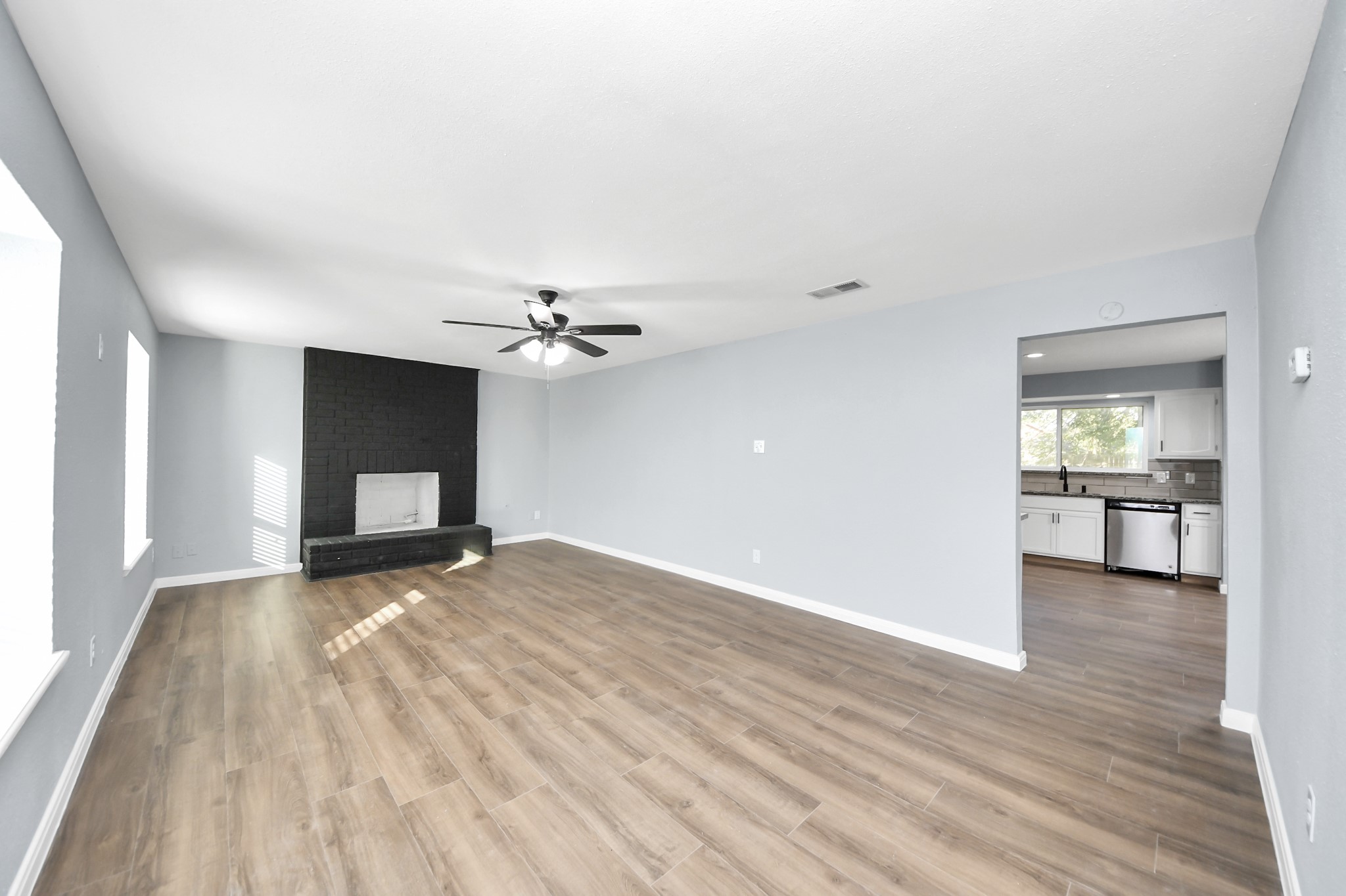 1806 Lacewing Lane Houston, TX 77067 - Photo 10 of 49 a view of a livingroom with a fireplace a ceiling fan and wooden floor