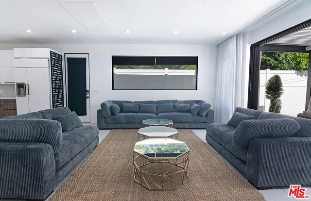 a kitchen with stainless steel appliances granite countertop sink stove and white cabinets with wooden floor