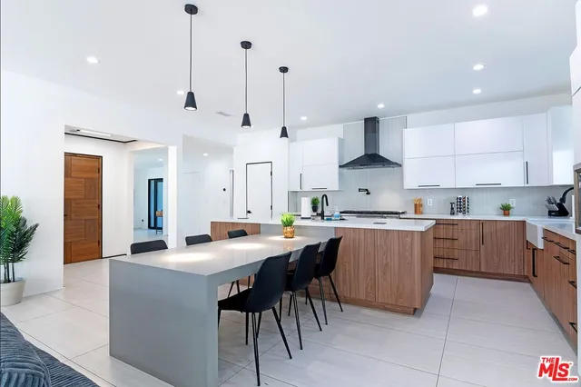 a kitchen with stainless steel appliances a sink a stove a microwave a refrigerator and cabinets