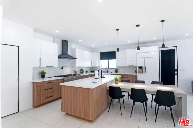 a kitchen with a sink a counter top space and living room view