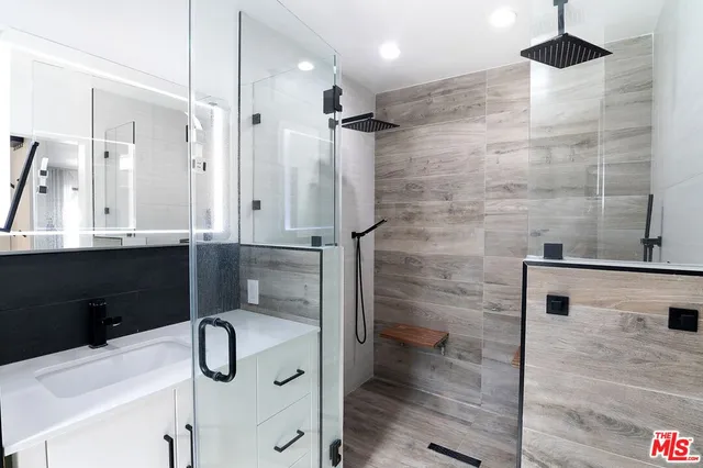 a bathroom with a sink and mirror with toilet