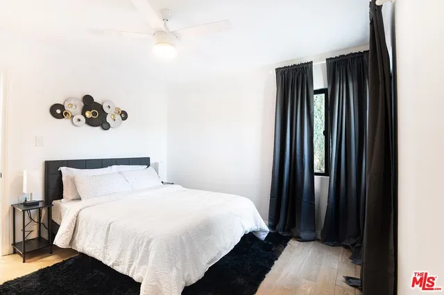 a bedroom with a bed and a potted plant