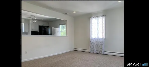 an empty room with windows and cabinet