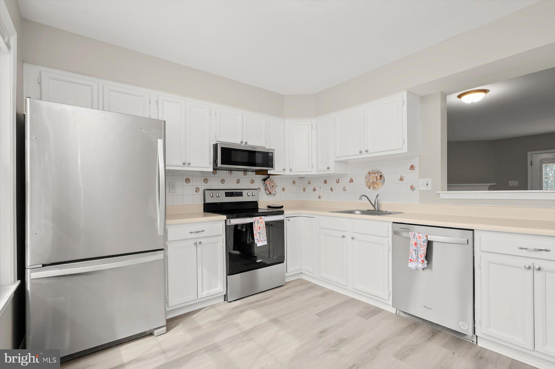 17 Offspring Court Perry Hall, MD 21128 - Photo 15 of 42 a kitchen with white cabinets and stainless steel appliances