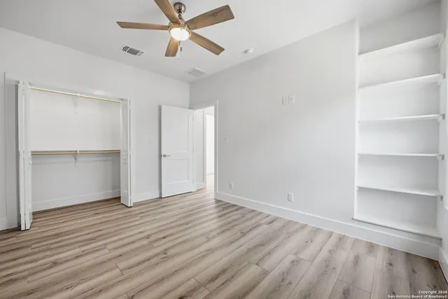 a bathroom with a granite countertop sink a toilet a mirror a bathtub and shower