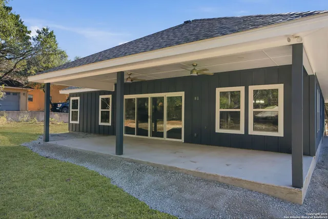 a view of an empty room with a window and ceiling fan