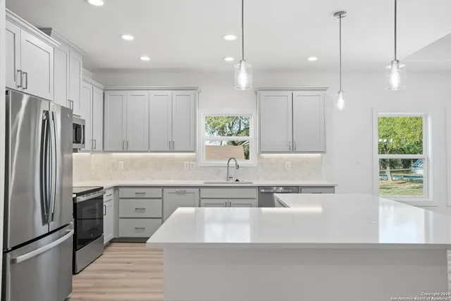 a kitchen with kitchen island white cabinets and stainless steel appliances
