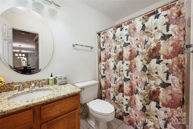 a bathroom with a granite countertop toilet sink and mirror
