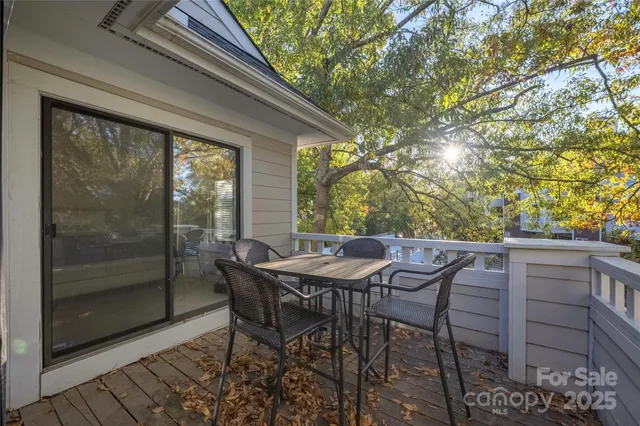 a view of a patio with table and chairs and floor to ceiling window