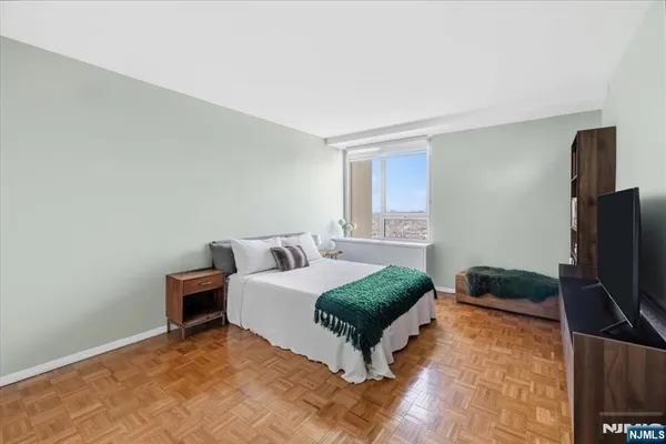 a living room with a bed furniture and a flat screen tv