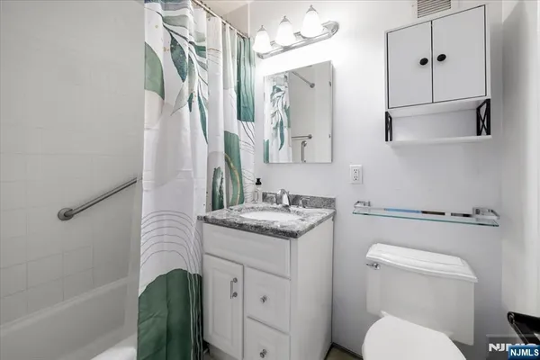 a bathroom with a granite countertop sink toilet and shower
