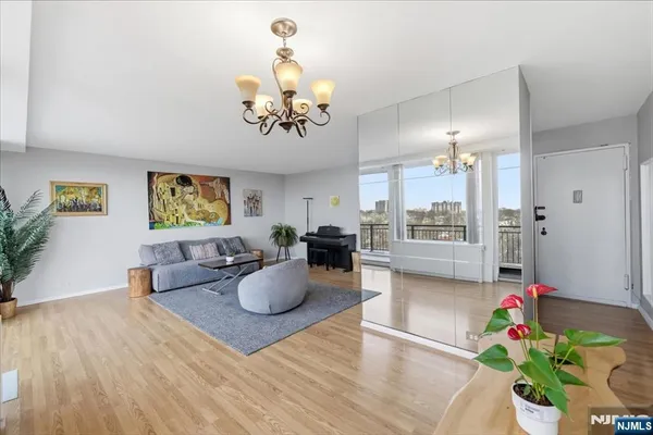 a view of a dining room with furniture a potted plant and wooden floor