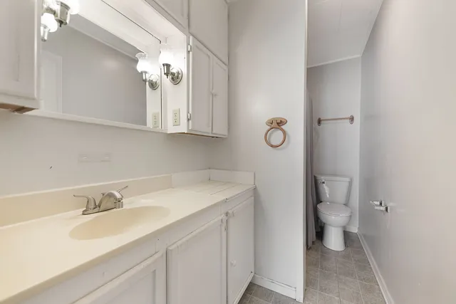 a bathroom with a sink toilet and a mirror