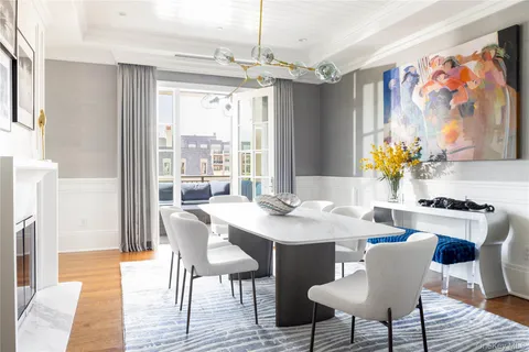 a dining room with furniture a large window and wooden floor