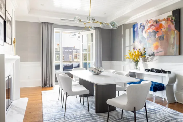 a dining room with furniture a large window and wooden floor