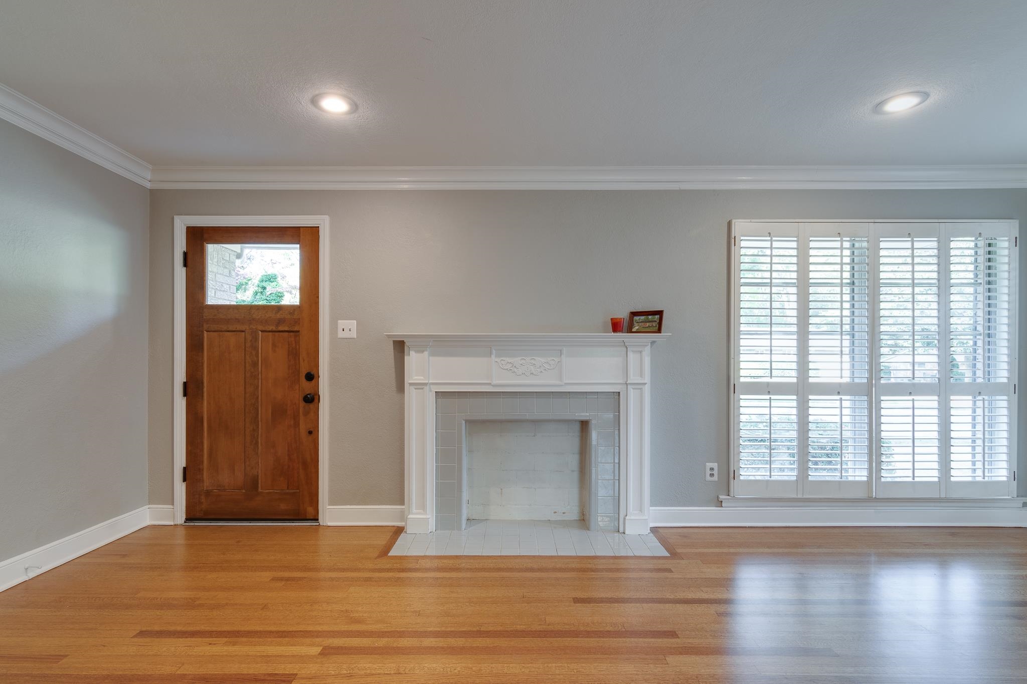 4165 Minden Road Memphis, TN 38117 - Photo 2 of 25 an empty room with wooden floor fireplace and windows