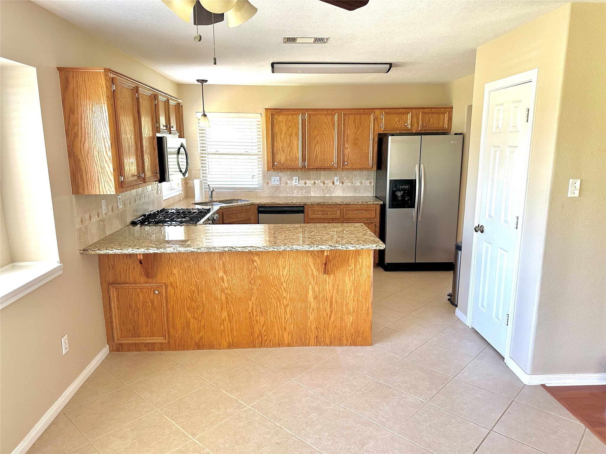 19303 Becker Road Hockley, TX 77447 - Photo 8 of 17 a view of a kitchen with stainless steel appliances granite countertop a refrigerator a sink and dishwasher