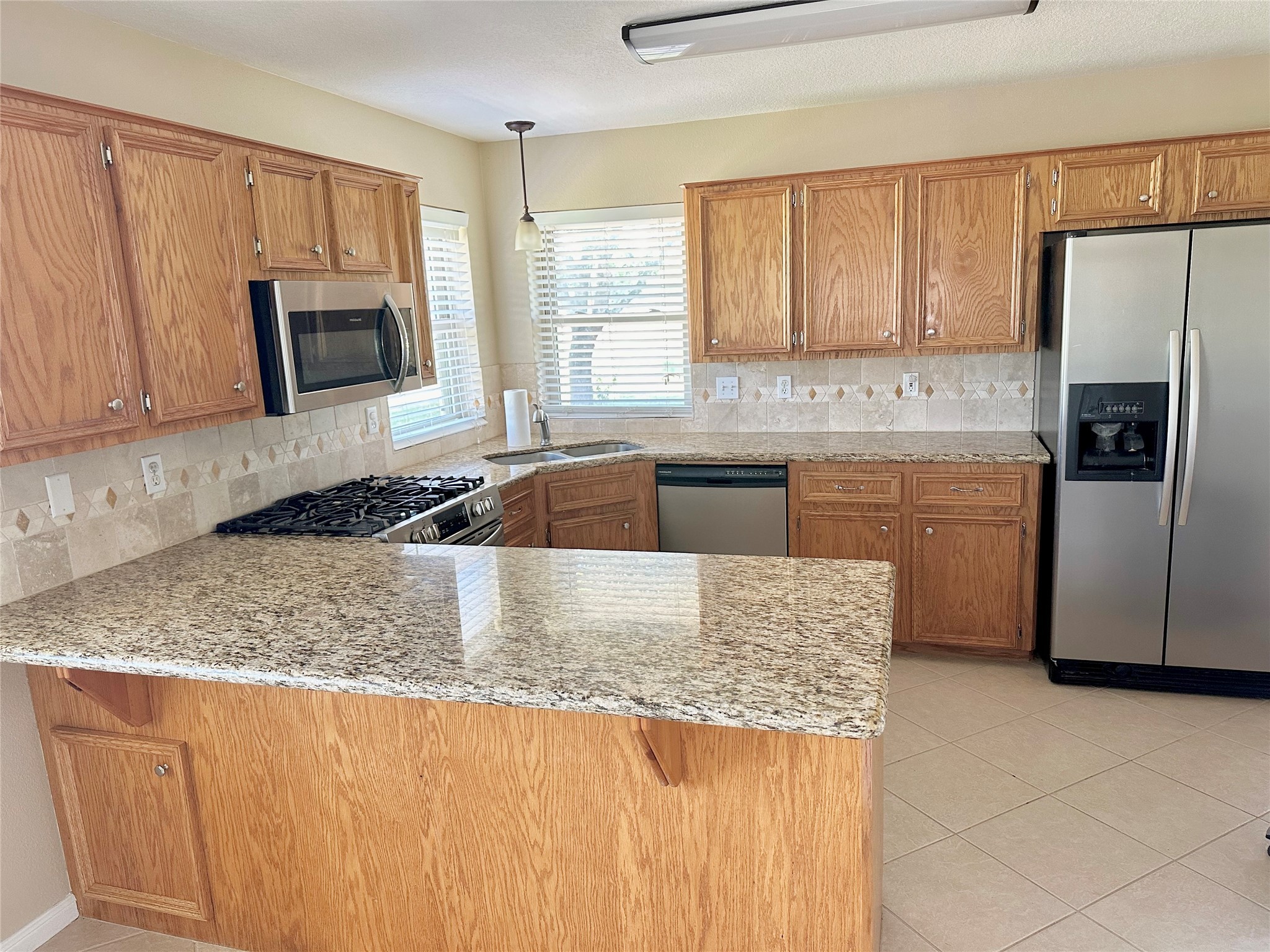 19303 Becker Road Hockley, TX 77447 - Photo 9 of 17 a kitchen with granite countertop a refrigerator stove and sink