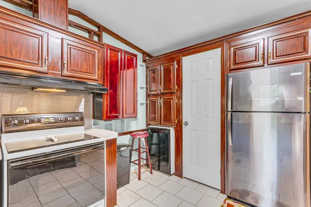a kitchen with stainless steel appliances granite countertop a refrigerator and a stove top oven