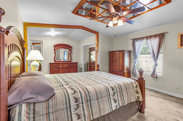 a bedroom with a bed and dresser with mirror