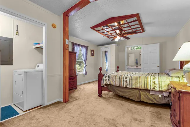 a spacious bedroom with a bed and a chandelier