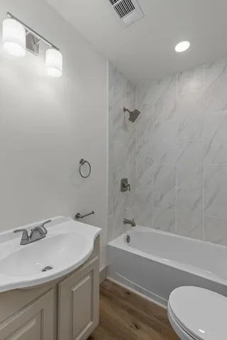 a bathroom with a sink toilet vanity and shower