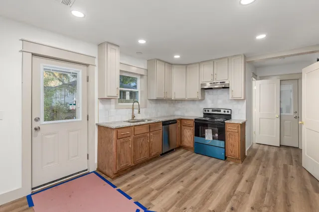 a kitchen with stainless steel appliances granite countertop a stove a sink and a refrigerator