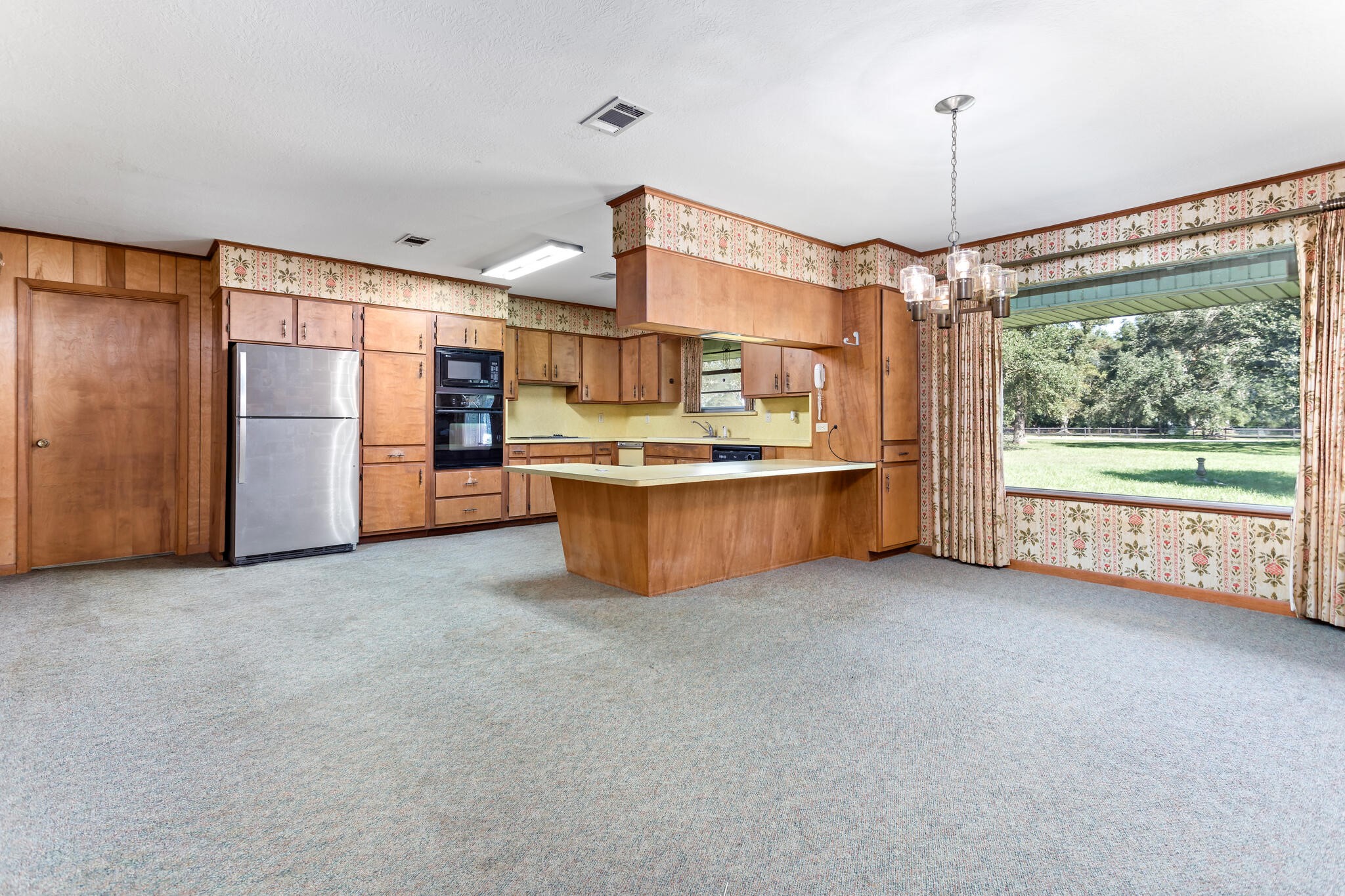 3030 Moore Road Beaumont, TX 77713 - Photo 12 of 38 a view of a kitchen with a fridge and a chandelier