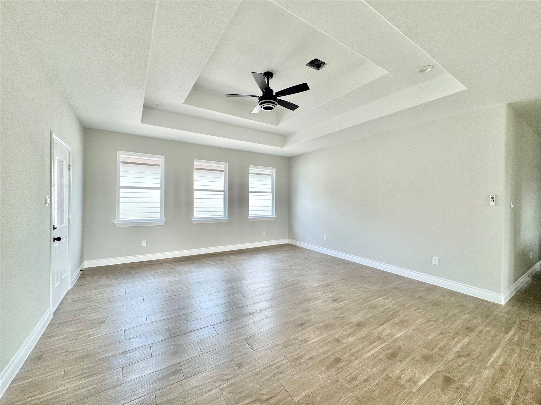 1165 Road 5203 Cleveland, TX 77327 - Photo 11 of 20 an empty room with wooden floor ceiling fan and windows