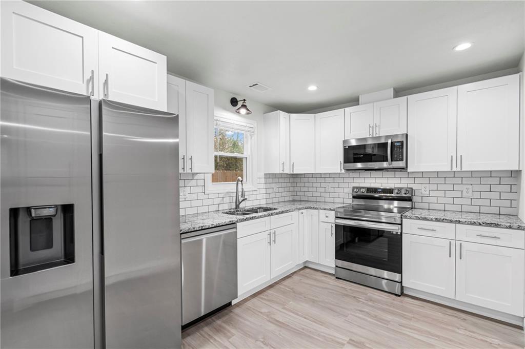 1342 North Hampton Road Alpharetta, GA 30009 - Photo 15 of 29 a kitchen with a sink stainless steel appliances and white cabinets