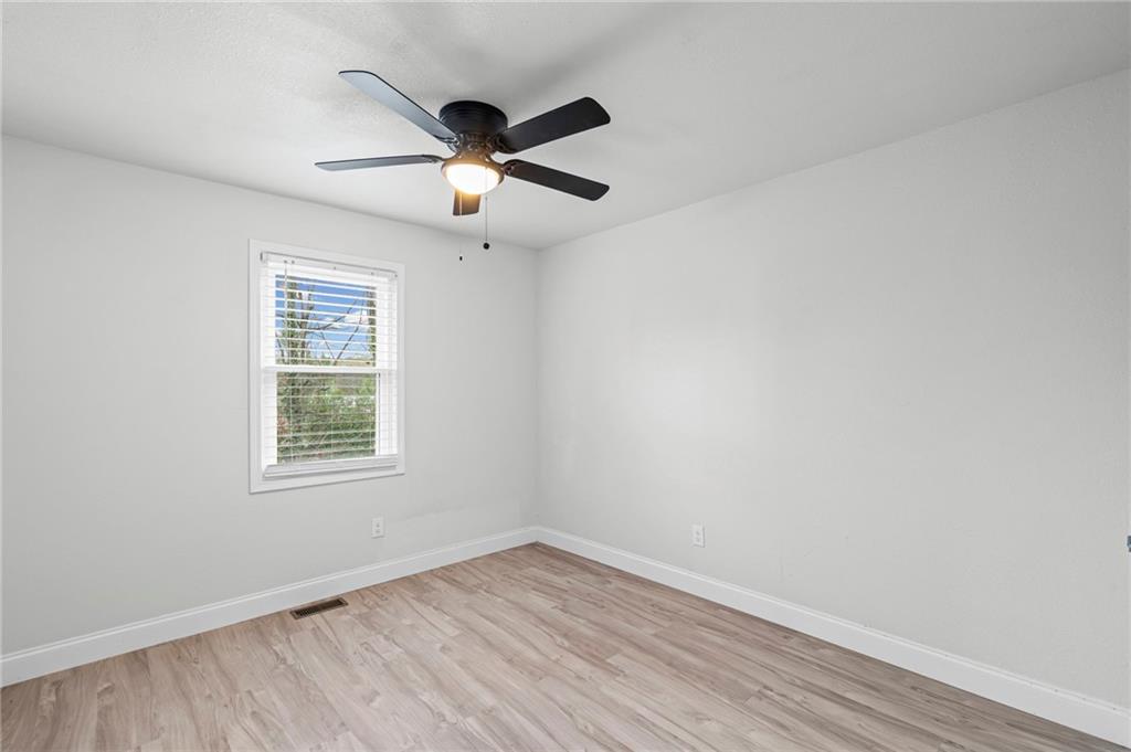 1342 North Hampton Road Alpharetta, GA 30009 - Photo 22 of 29 an empty room with wooden floor fan and windows