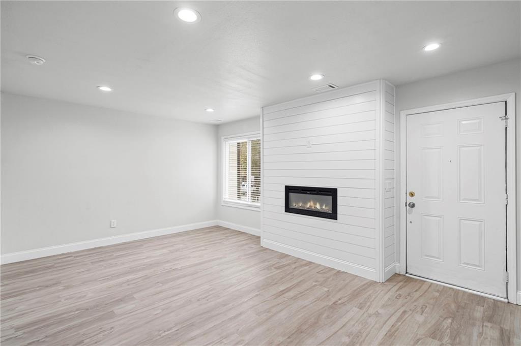 1342 North Hampton Road Alpharetta, GA 30009 - Photo 9 of 29 an empty room with wooden floor and fireplace