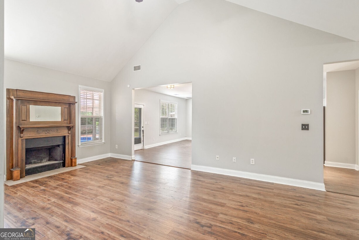 82 Newton Road LaGrange, GA 30240 - Photo 20 of 45 an empty room with wooden floor fireplace and windows
