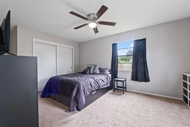 a bedroom with a bed and a flat tv screen on dresser