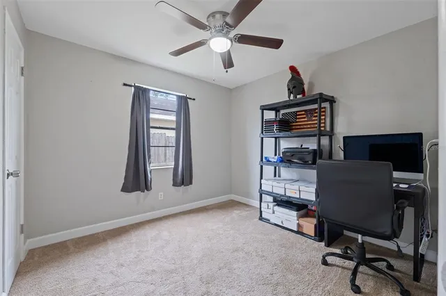 a view of a workspace with furniture and a window