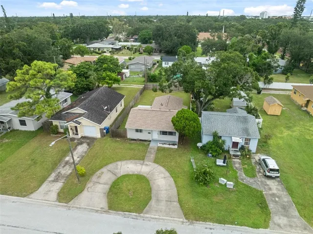 an aerial view of residential houses with outdoor space and trees