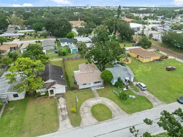 an aerial view of a house with a garden and lake view