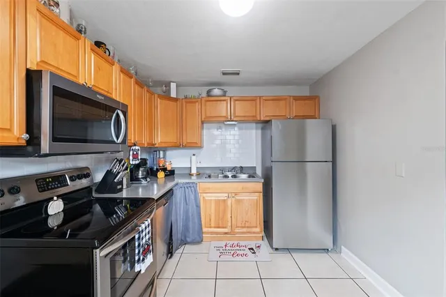 a kitchen with stainless steel appliances granite countertop a refrigerator stove a sink dishwasher and microwave oven