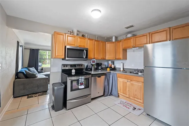 a kitchen with granite countertop appliances a sink cabinets and a window