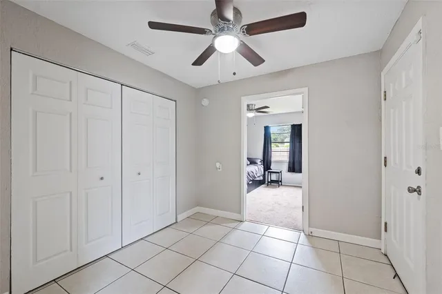 a view of a livingroom with a chandelier fan and kitchen in the house