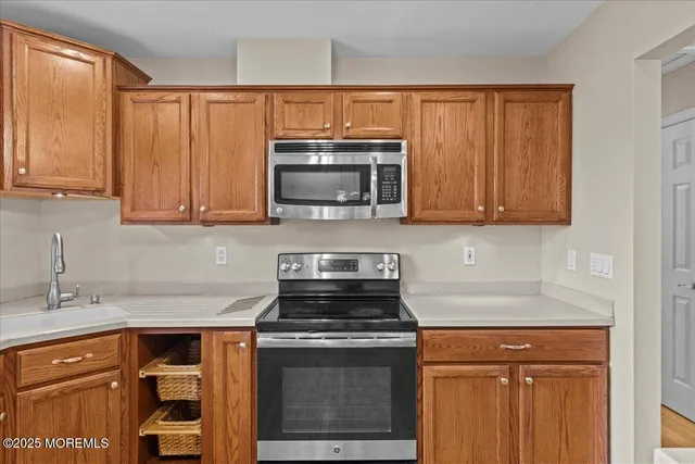 a kitchen with granite countertop a stove top oven microwave and cabinets