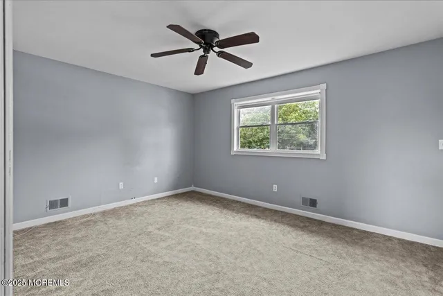 a view of room with ceiling fan and window