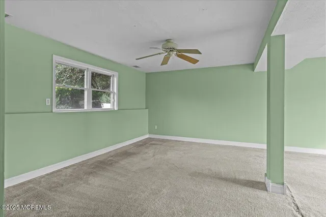 an empty room with windows and cabinet